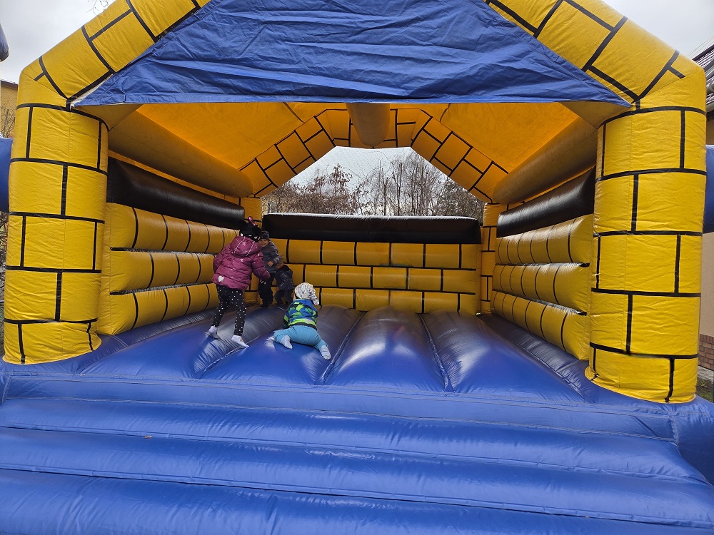 Kinder spielen fröhlich in der gelb-blauen Hüpfburg